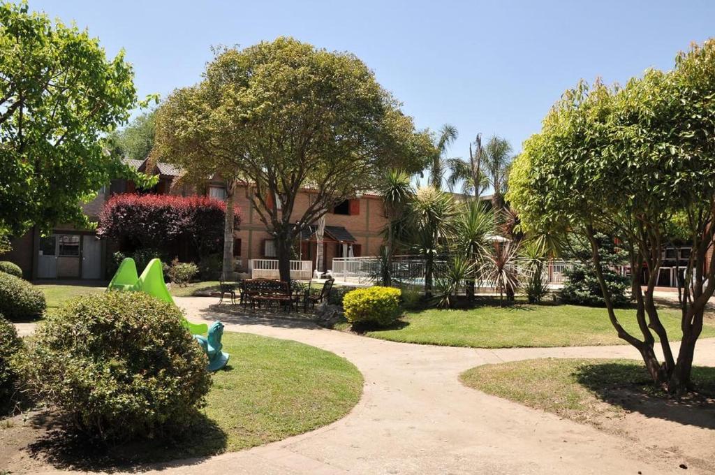 a park with a playground and trees and a building at Cabañas Nazareth in Villa Carlos Paz