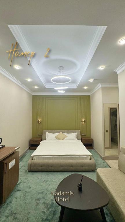 a large bedroom with a bed and a table at Radamis in Almaty