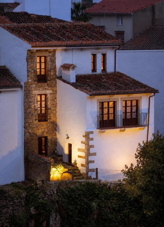 a white house with its lights on at night at Casa Rural Canchalejo in Montánchez