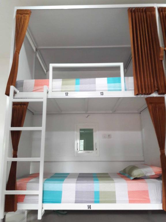 una camera con due letti a castello in una stanza di Huize Jon Hostel a Malang