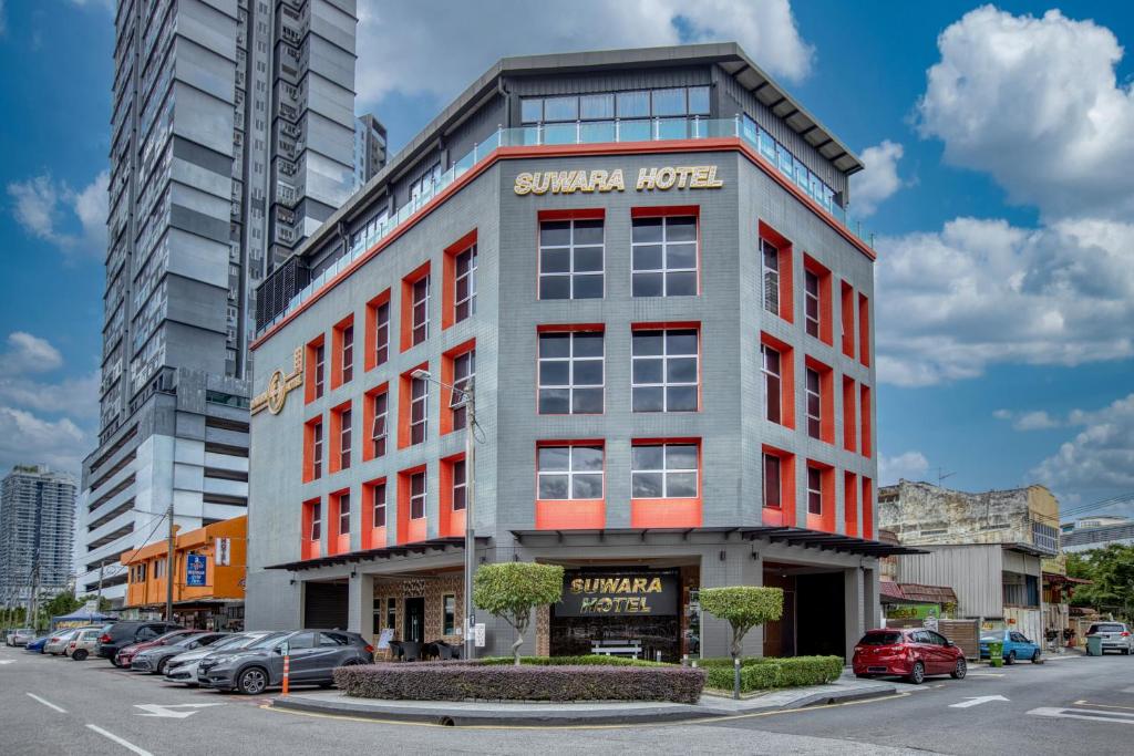 a large building on a city street with cars parked at Suwara Hotel Kepong KL in Kuala Lumpur