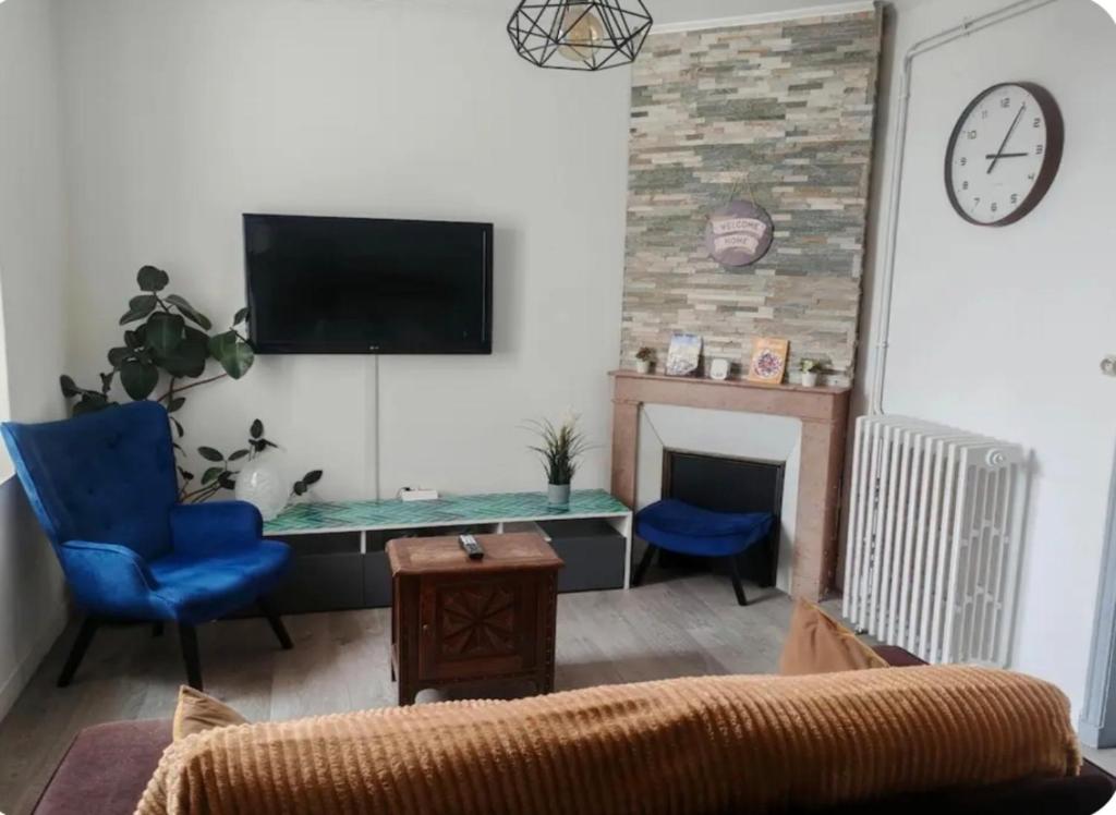 a living room with a table and a clock on the wall at La Parenthèse Auvergnate, F3 2 Chambres Clermont-Ferrand,Climatisation, Parking in Clermont-Ferrand