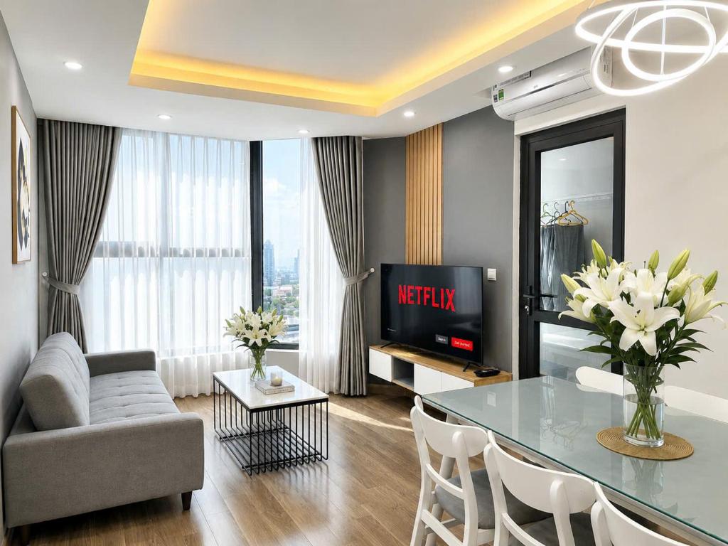 a living room with a television and a table and chairs at 2-3 bedroom at HUD building Nha Trang in Nha Trang