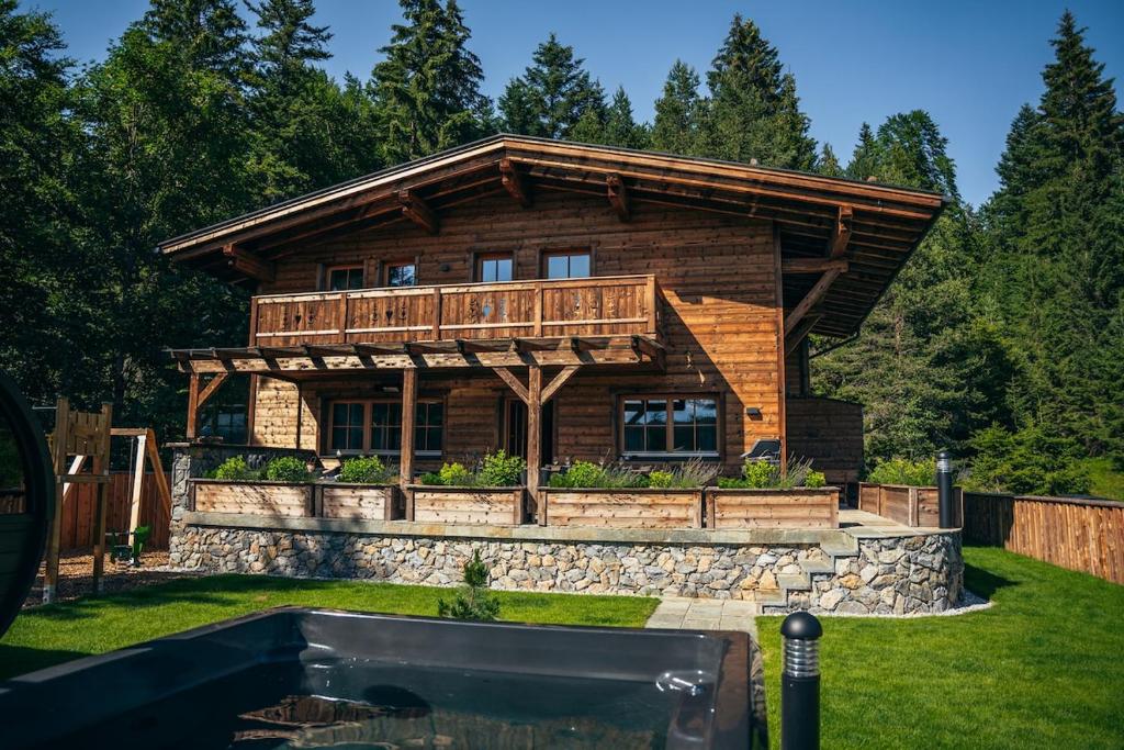 a log cabin with a pool in front of it at Alpin Chic by Alpe Chalets in Unterseefeld