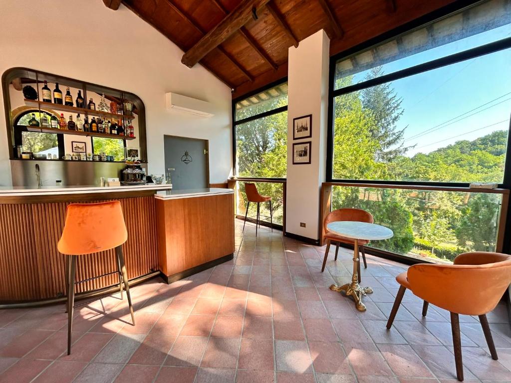 a room with a bar and some chairs and windows at Adagio Umbro in Sustrico Di Spoleto