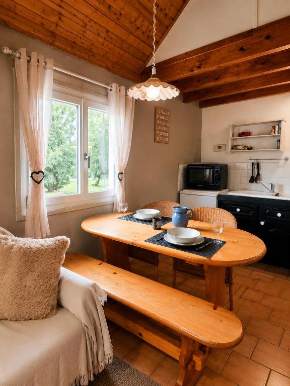 a living room with a wooden table and a kitchen at Duplex le Grimpeur - Les Apparts du Sancy in Chastreix