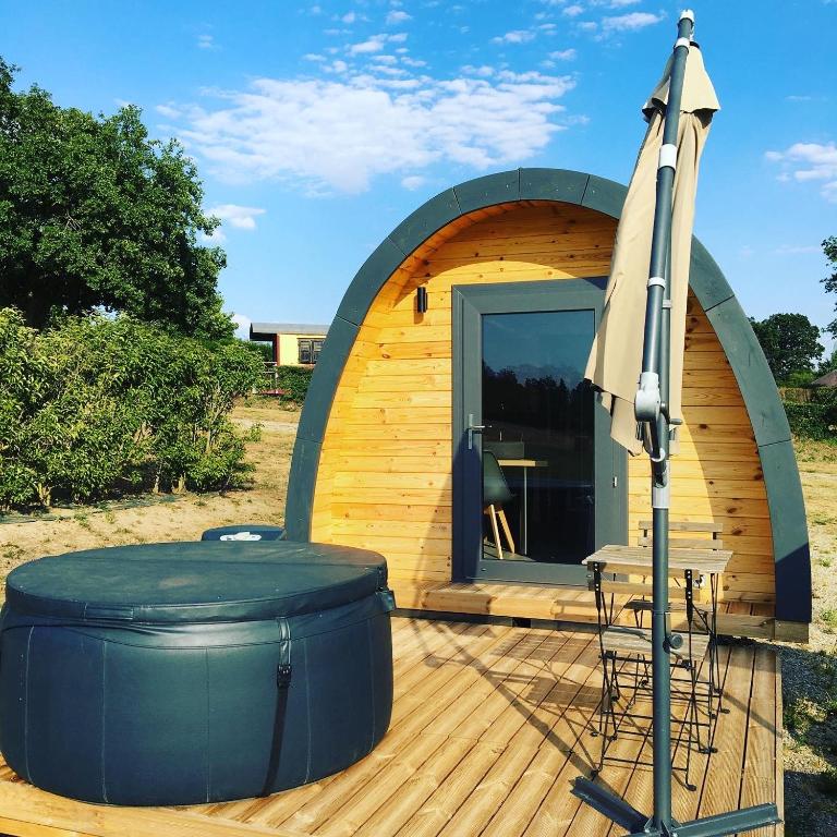 a circular house with a table and an umbrella at Lodge des Bois Jacuzzi in Target