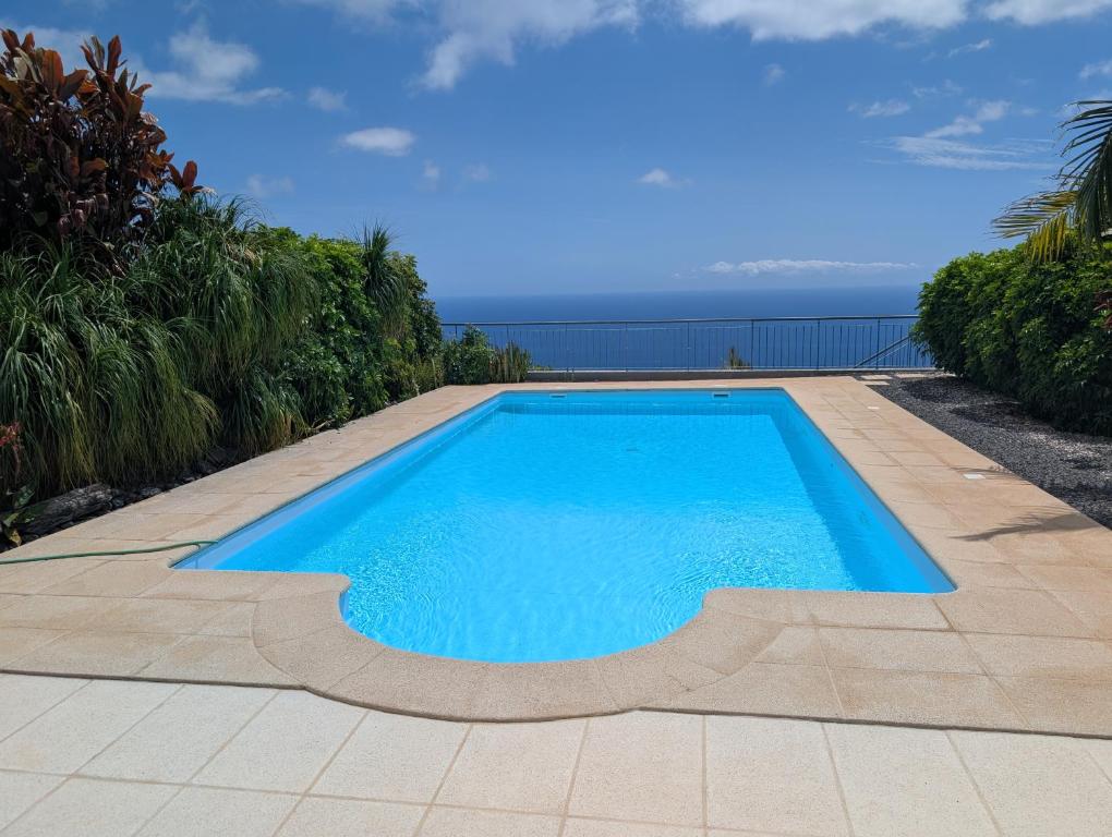 a swimming pool with the ocean in the background at Loreto Luxury in Arco da Calheta