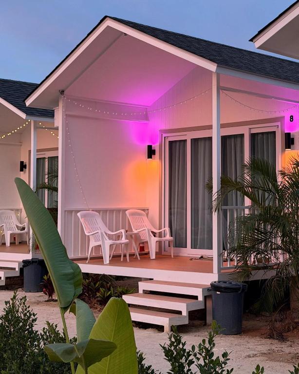 a house with a deck with chairs and purple lights at Travellers Palm in Ko Phangan