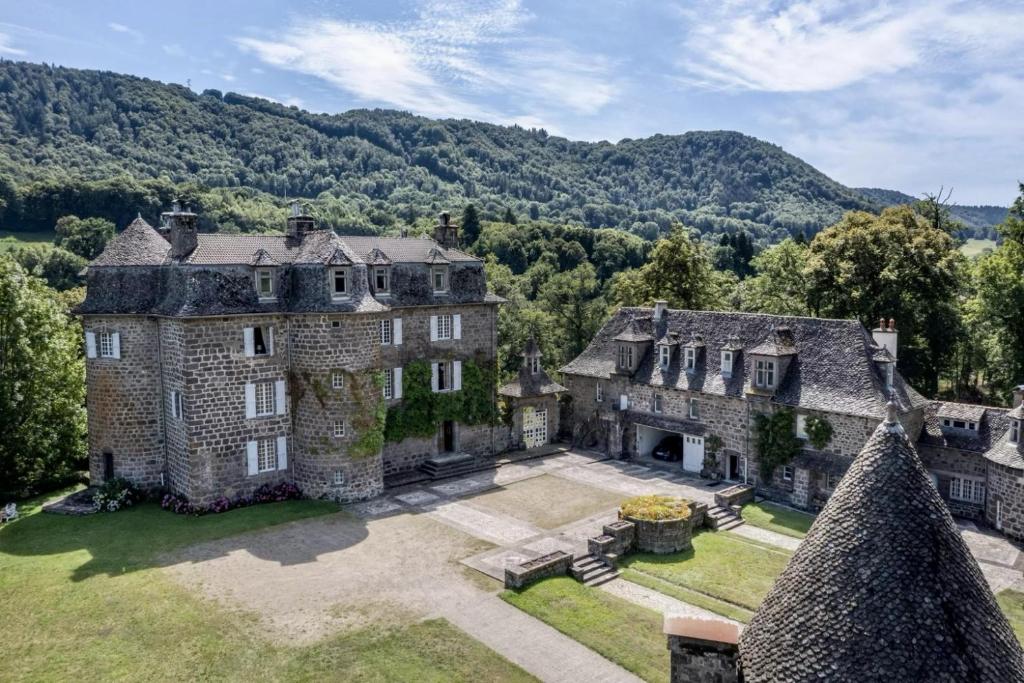 an aerial view of a mansion with mountains in the background at Château de La Voulte in Marmanhac