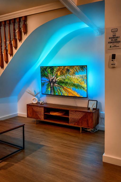 a flat screen tv sitting on top of a wooden entertainment center at Alojamiento Rural Ciudad Monumental in Baeza