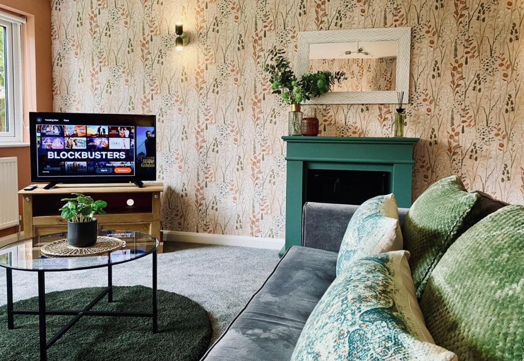a living room with a couch and a tv at Foxcroft in Brighouse