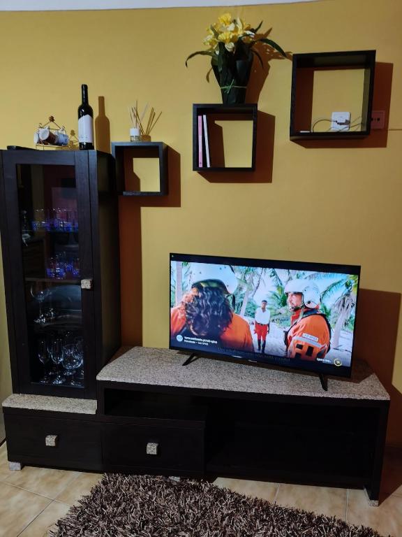 a flat screen tv sitting on a stand in a living room at Blue House in Ucanha
