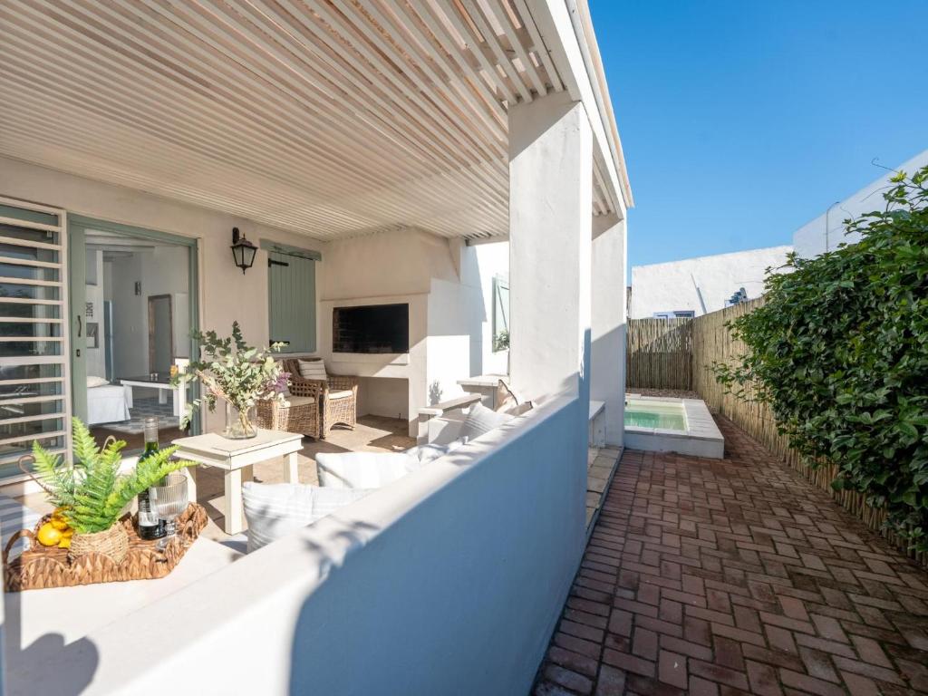 an outdoor patio with white chairs and a television at Rose Pearl in Paternoster
