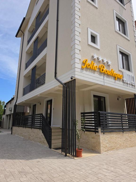a building with a sign on the front of it at Jolie Boutique Hotel Corp B in Craiova