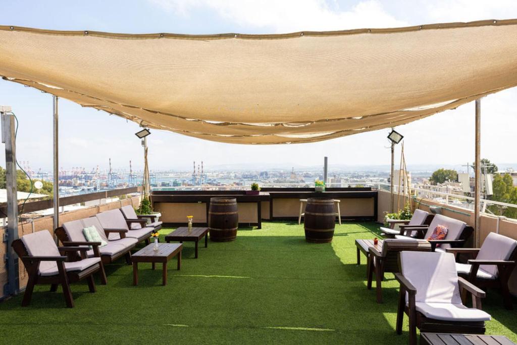 a rooftop patio with chairs and a view of the city at City Center Apartments in Haifa