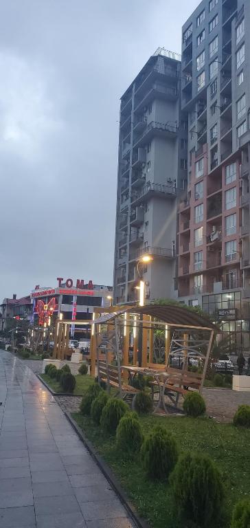 a park with a bench in front of some buildings at Nodari in Batumi