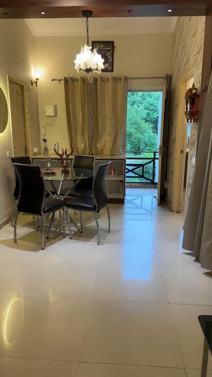 a dining room with a glass table and chairs at 22nd Weekend Stays in Bhīm Tāl