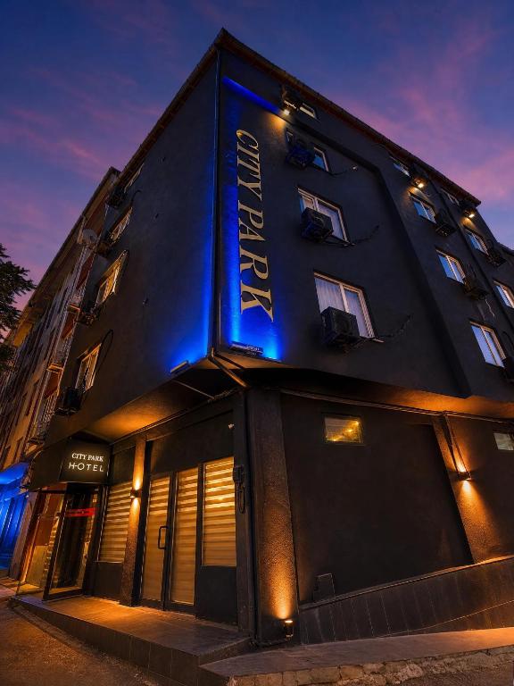 a building with a blue sign on the side of it at City Park Suites City Center Corlu in Çorlu