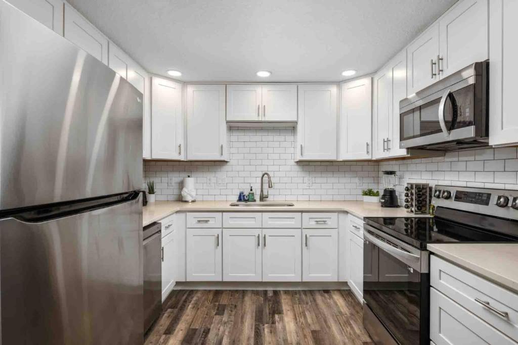 a kitchen with white cabinets and a stainless steel refrigerator at Wintergreen Unit 1 in Salem
