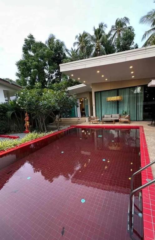 a house with a large pool of red tiles at Villa with the red pool in Hinkong