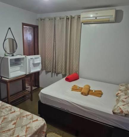 a hotel room with two beds and a tv at Hotel Teixeira in Rio Verde