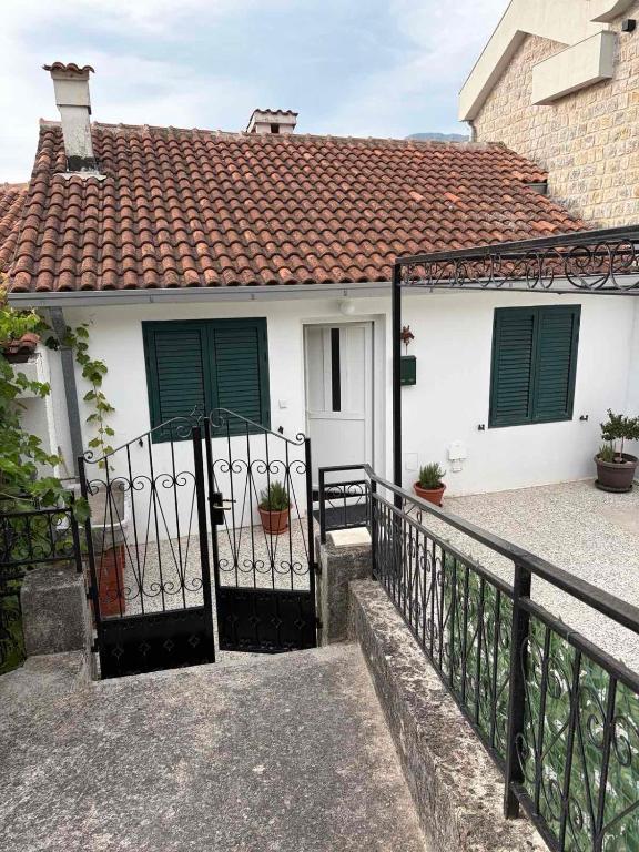 a white house with green shutters and a fence at Lavanda in Budva