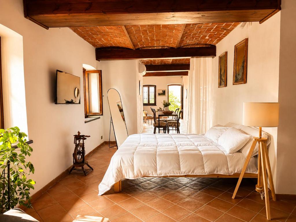 a bedroom with a bed and a dining room at Country Loft Colle Miroteo in Monforte dʼAlba