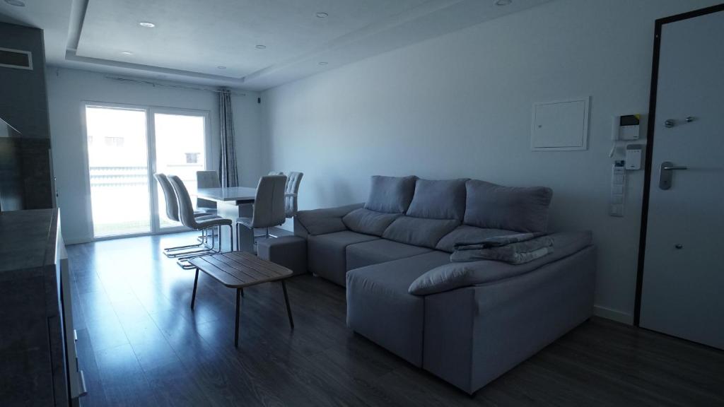 a living room with a couch and a table at Moradia T4 Fernão Ferro in Fernao Ferro