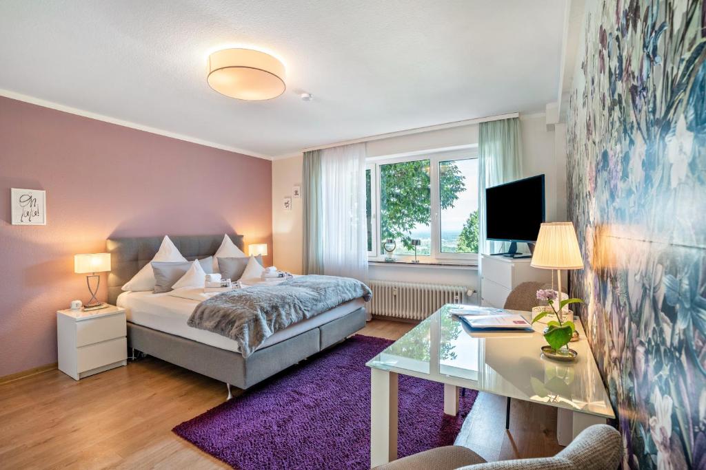 a bedroom with a bed and a desk and a glass table at Baden-Chalet - Wandergenuss in Bühl