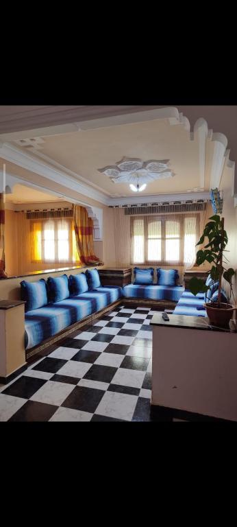 a living room with blue couches on a checkered floor at casa chawni in Chefchaouen