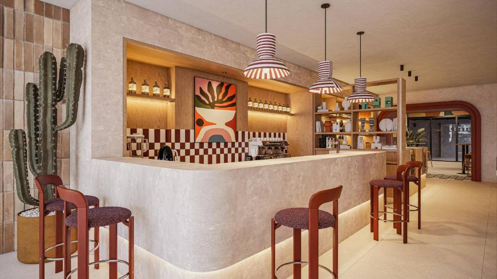 a restaurant with a bar with stools at INNSiDE by Meliá Mexico Roma Norte in Mexico City