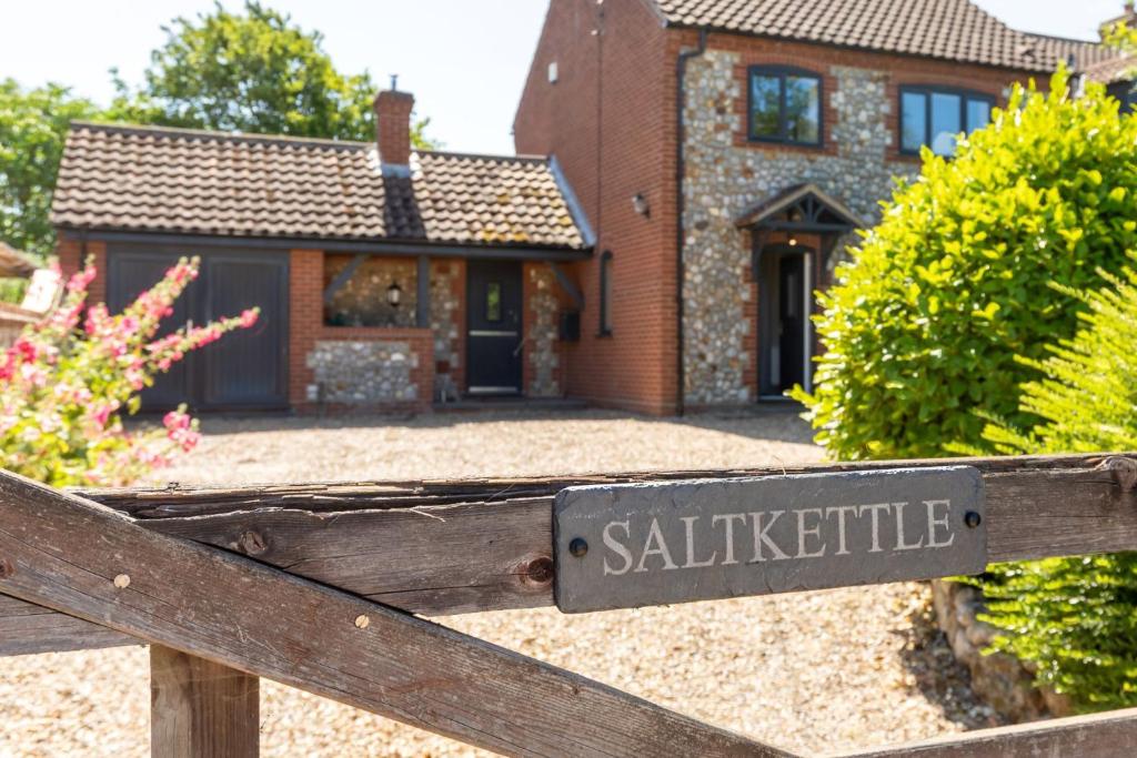 a sign on a fence in front of a house at Saltkettle Sanctuary, Blakeney By Together Travel in Blakeney