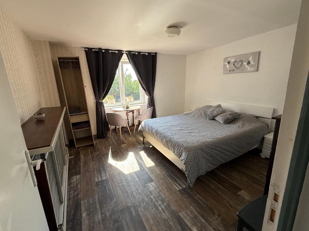 a bedroom with a bed and a desk and a window at Chambre d'hotes 2 à Bramefort in Champsac