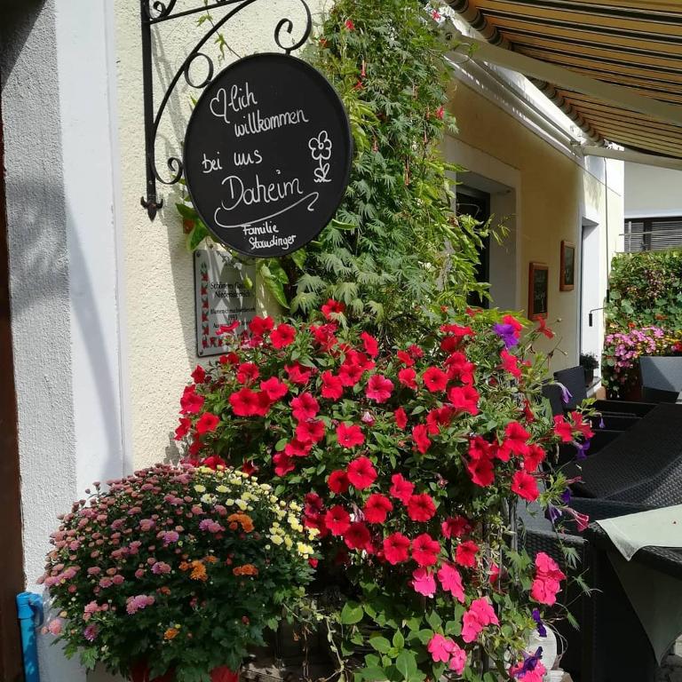 a sign on the side of a building with flowers at Pension Landhaus Ingrid in Loich