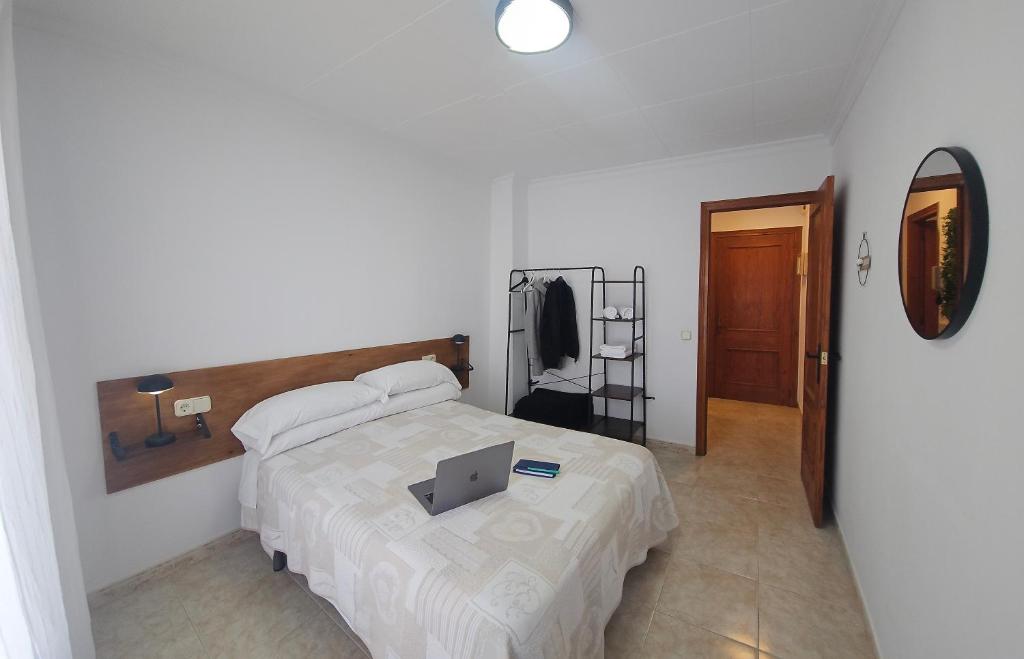a bedroom with a bed with a laptop on it at Cosy Apartament Figueres in Figueres