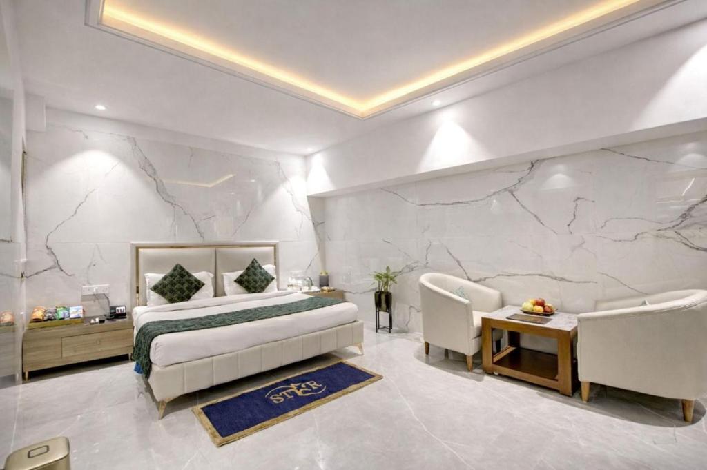 a bedroom with a bed and a couch and a table at Hotel ravan in New Delhi