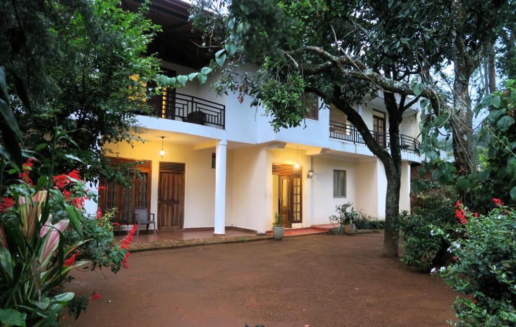 a white house with a courtyard in front of it at Hotel mango tree nearest Adam's peak in Nallathanniya