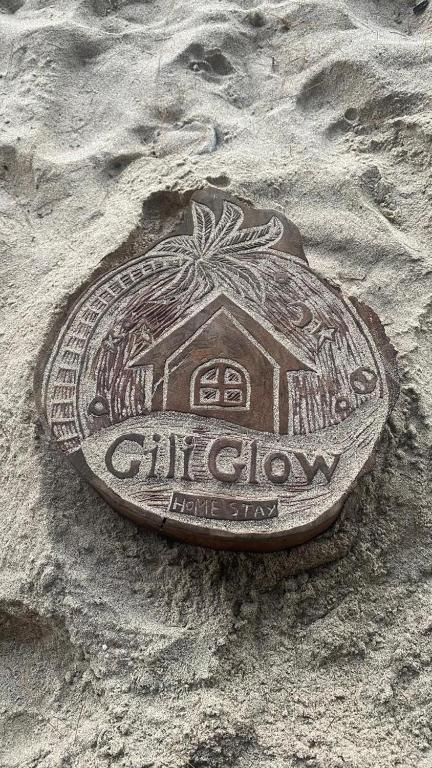 a plaque in the sand on a beach at Gili Glow Homestay in Gili Trawangan
