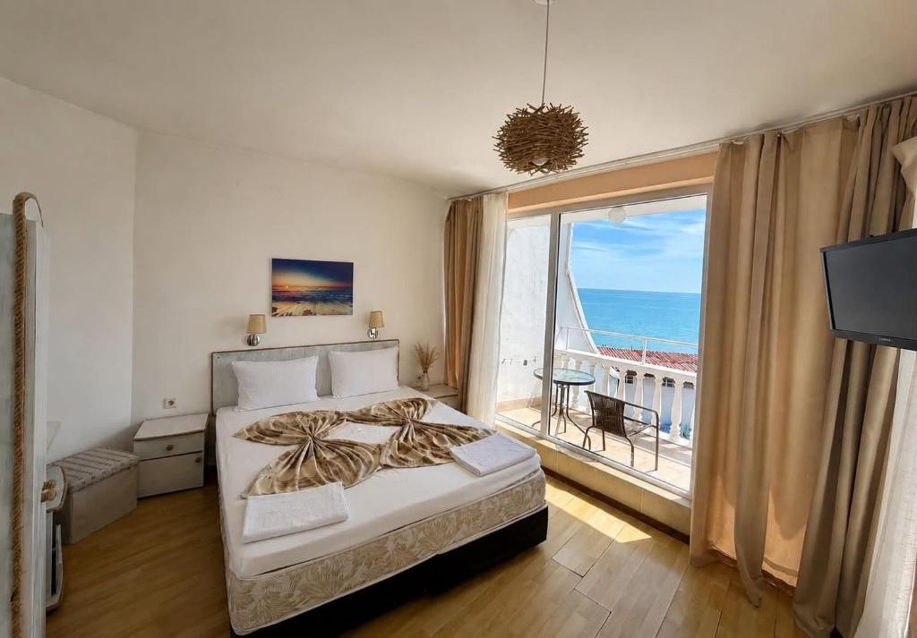 a bedroom with a bed and a view of the ocean at Riviera Beach Hotel in Sozopol