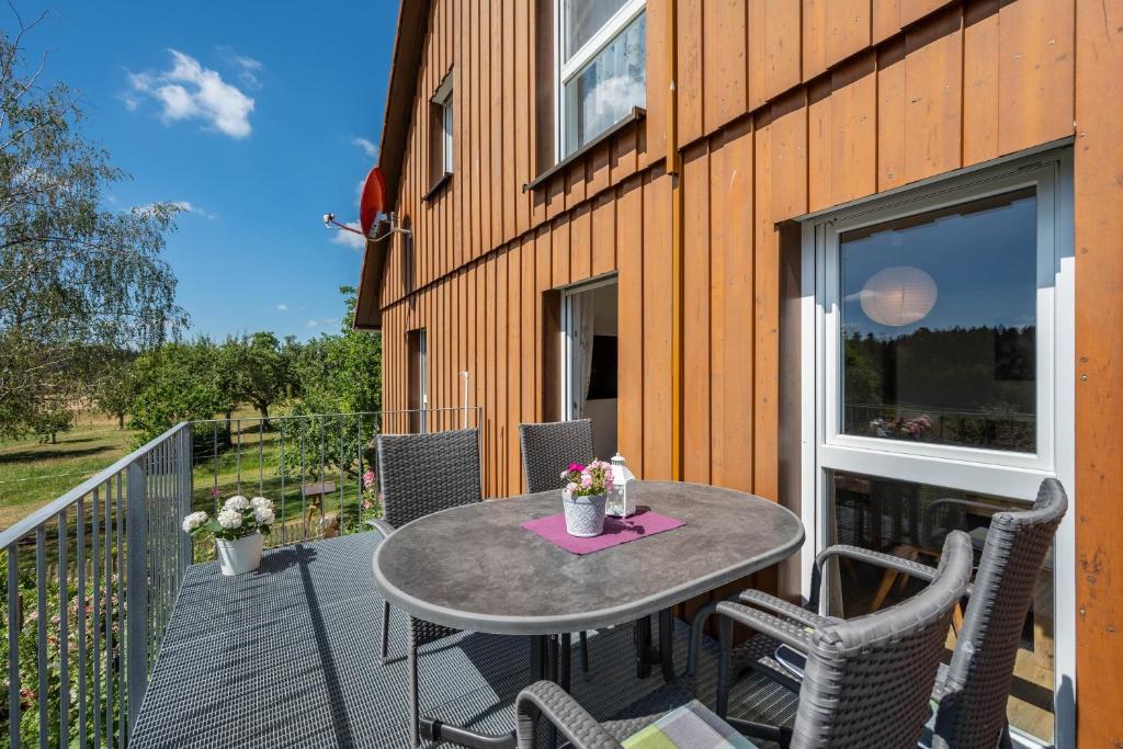 a patio with a table and chairs on a balcony at Fuchskreuzhof Simmersfeld in Simmersfeld