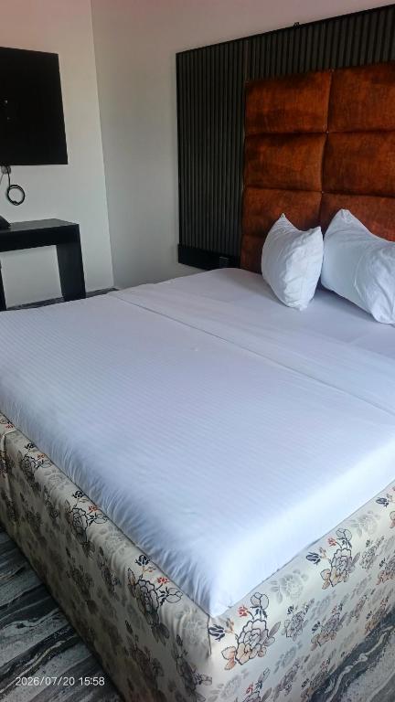 a bedroom with a large bed with white sheets at Eraton Hotel in Warri
