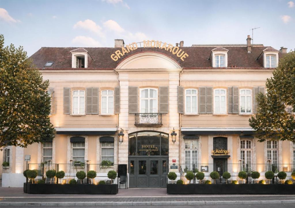 a large tan building with a sign on it at Hotel & Spa Le Grand Monarque, BW Premier Collection in Chartres