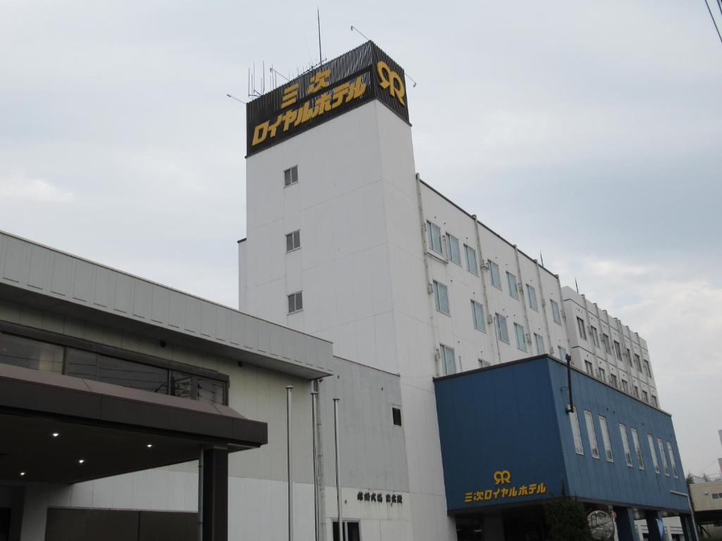 a white building with a sign on the top of it at Hotel CROWN HILLS MIYOSHI in Miyoshi