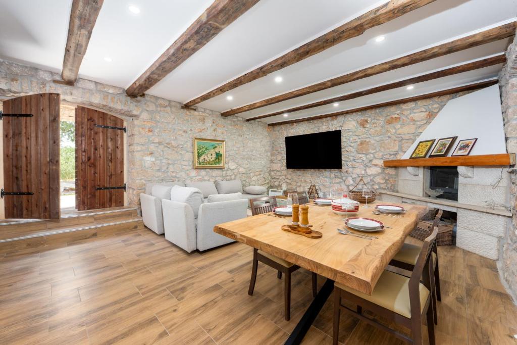 a living room with a table and a couch at Authentic Dalmatian Stone House-Kameni dvori in Selca kod Bogomolja
