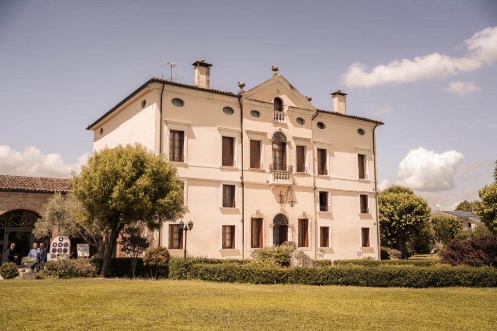 a large white building on a grassy field at Villa Bongiovanni in San Bonifacio