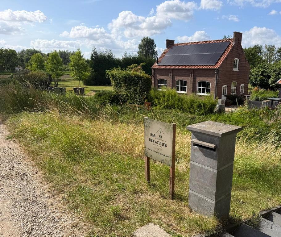 a sign in front of a house with a building at Het Atelier Schuring - Luxe vakantiehuis 78m2 in Numansdorp