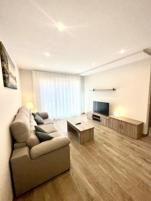 a living room with a couch and a flat screen tv at Apartamento La Muralla 2B in Aguilar de Campóo