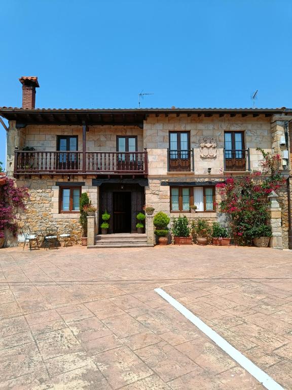 a large stone building with a parking lot in front of it at Posada Herrán in Santillana del Mar