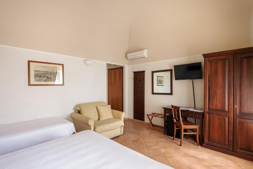 ein Hotelzimmer mit Bett, Schreibtisch und Fernseher in der Unterkunft Hotel San Claudio in Corridonia